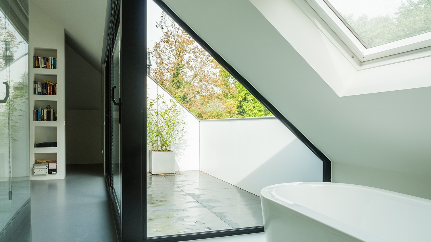 Verbouwing en renovatie zolder met loggia. Een in het dakvlak liggende loggia geeft licht en ruimte in de zolder. Zo kun je buiten staan op de zolder. Het geeft ook prachtig zicht op de bomen.