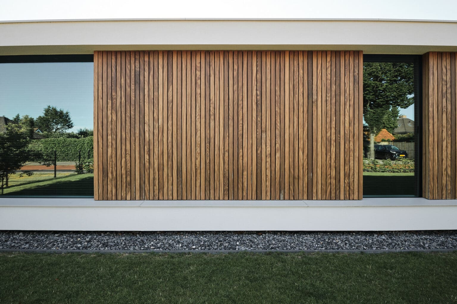 van-Os-Architecten-nieuwbouw-woning-bungalow-Prinsenbeek-detail-voorgevel-met-houten-delen-en-wit-stucwerk-vloer-en-dak