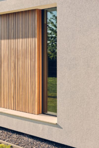 van-Os-Architecten-nieuwbouw-woning-bungalow-Prinsenbeek-detail-zijgevel-met-raam-naast-hout-in-stucwerk
