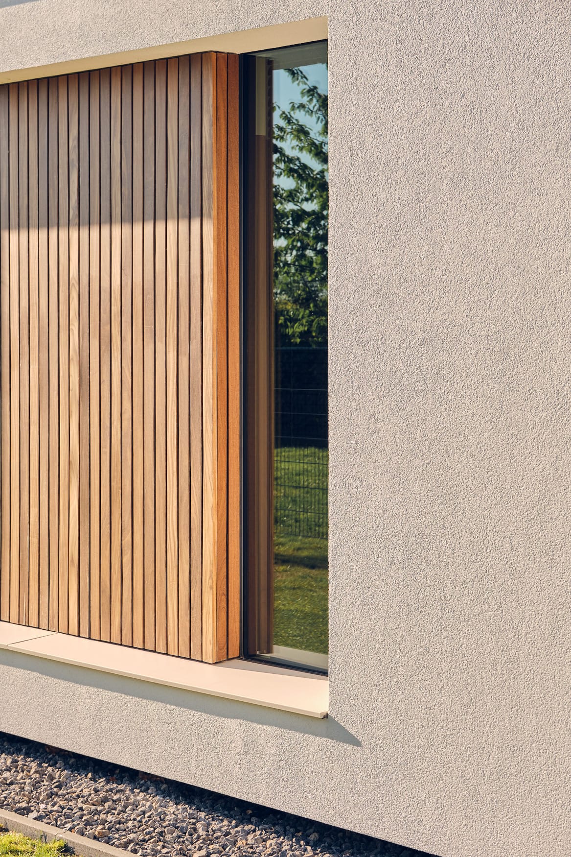 van-Os-Architecten-nieuwbouw-woning-bungalow-Prinsenbeek-detail-zijgevel-met-raam-naast-hout-in-stucwerk