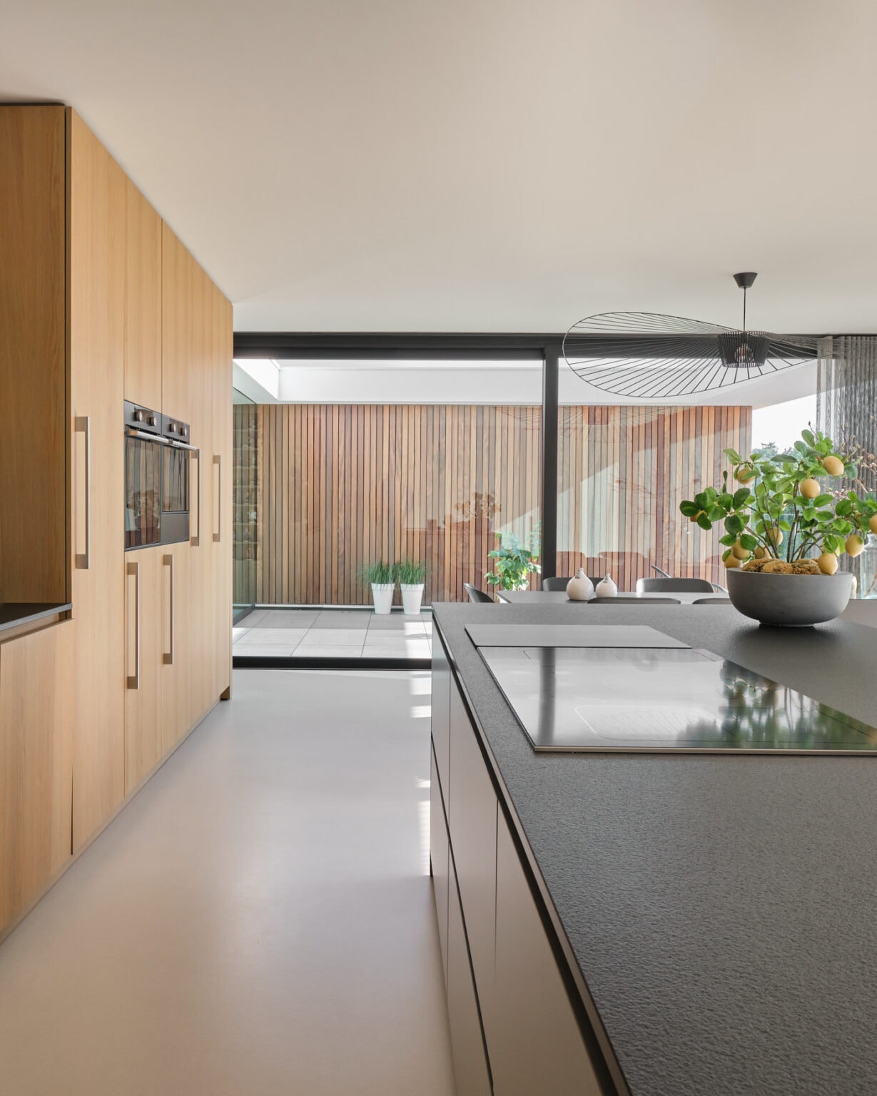 van-Os-Architecten-nieuwbouw-woning-bungalow-Prinsenbeek-interieur-met-woonkeuken-en-zicht-op-patio-met-houten-cedar-latten